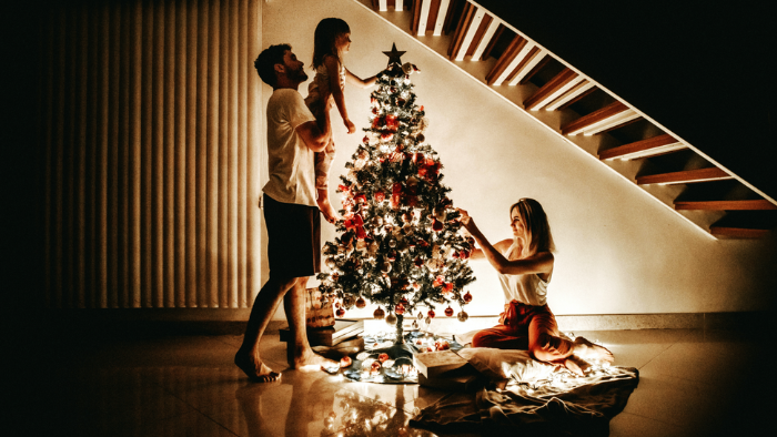 Family decorating christmas tree on christmas eve night.