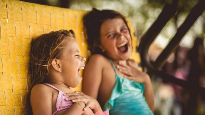 Two girls laughing at shared secrets